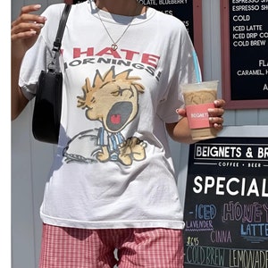 オーバーサイズのヴィンテージ「I Hate Mornings」Tシャツ、90年代のTシャツ、ユニセックスのクラシックTシャツ、バギーフィットのグラフィックTシャツ、トレンディなTシャツ、ユーモアアパレル。