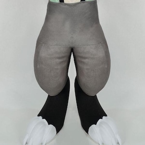 May include: A costume piece featuring gray padded shorts and black legs with white claw-like feet. The shorts have a rounded shape, and the feet have a feathery appearance. The costume is designed to resemble an animal.
