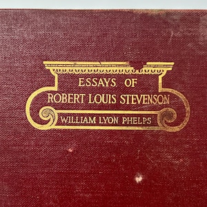Peut inclure: Une couverture de livre rouge avec des lettres dorées qui disent "Essays of Robert Louis Stevenson" et "William Lyon Phelps".