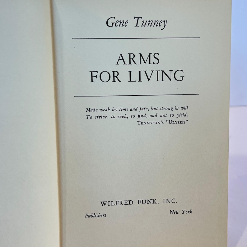 May include: A book titled "Arms for Living" by Gene Tunney. The book cover is cream coloured with black text. The quote "Made weak by time and fate, but strong in will To strive, to seek, to find, and not to yield. TENNYSON'S "ULYSSES"" is printed on the cover. The book is published by Wilfred Funk, Inc. in New York.