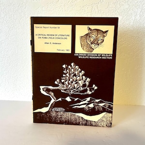 May include: A brown and white cover of a report titled "A Critical Review of Literature on Puma (Felis Concolor)" by Allen E. Anderson. The report is from the Colorado Division of Wildlife Wildlife Research Section and was published in February 1983. The cover features a drawing of a mountain lion and a pine tree.