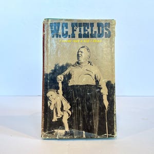 May include: A vintage paperback book with a black and white photo of W.C. Fields holding a young girl's hand. The book title is "W.C. Fields I never met a kid I liked."