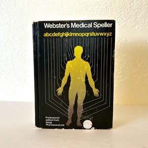 May include: Black book with the title "Webster's Medical Speller" and the alphabet in yellow letters. A yellow outline of a human body is in the center of the cover. The book is a professional edition from Geigy Pharmaceuticals.