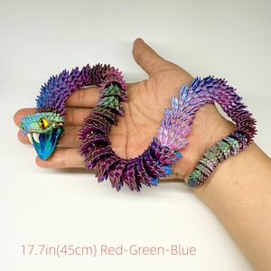 May include: A multi-colored, articulated snake toy, approximately 17.7 inches (45 cm) long, with a vibrant gradient of red, green, and blue hues. The snake's head is open-mouthed with yellow eyes. The body is segmented, allowing for flexible posing.