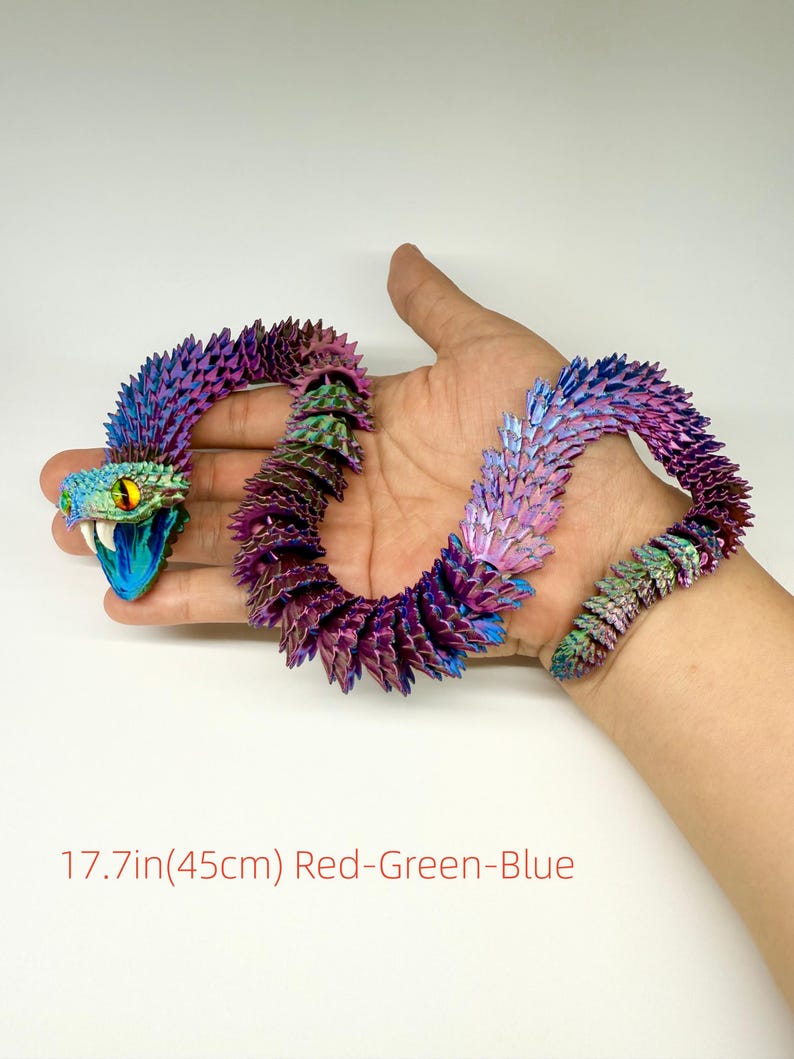 May include: A multi-colored, articulated snake toy, approximately 17.7 inches (45 cm) long, with a vibrant gradient of red, green, and blue hues. The snake's head is open-mouthed with yellow eyes. The body is segmented, allowing for flexible posing.