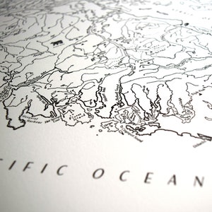 May include: A monochrome map print showing detailed coastlines, rivers, and geographical features. The words "PACIFIC OCEAN" are printed in a serif font at the bottom. The map appears to be of a coastal region.