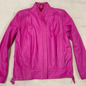 Può includere: Una giacca di pelle rosa brillante con chiusura a zip e colletto alto.