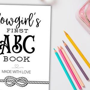 May include: A black and white printable book cover with the text "Cowgirl's First ABC Book" and "Made with Love". The cover also features a decorative rope knot.