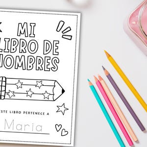 May include: A black and white coloring book titled "MI LIBRO DE NOMBRES" with a pencil illustration and stars. The book is designed for children to write their name. Colored pencils in various colors are scattered around the book.