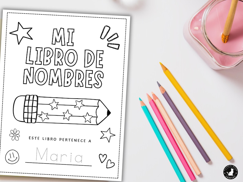 May include: A black and white coloring book titled "MI LIBRO DE NOMBRES" with a pencil illustration and stars. The book is designed for children to write their name. Colored pencils in various colors are scattered around the book.