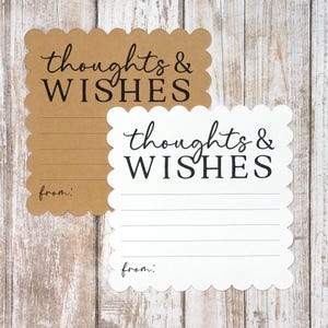 May include: Two scalloped-edge cards, one brown and one white, with the words "thoughts & WISHES" in black script. Each card has lined space for writing and the word "from:" at the bottom. The cards are on a light wood background.