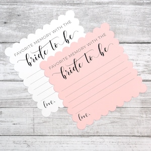 May include: Two white cards with pink scalloped edges. The cards have the text "FAVORITE MEMORY WITH THE bride to be" and a line for writing. The cards have the word "love." at the bottom.