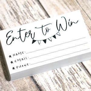 May include: White card with black text that reads "Enter to Win" with a string of black and white pennants. The card has three lines for entering name, email, and phone number.