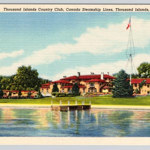 K&ouml;nnte beinhalten: Eine Vintage-Postkarte des Thousand Islands Country Club, Canada Steamship Lines, Thousand Islands, New York. Das Bild zeigt ein gro&szlig;es beiges Geb&auml;ude mit rotem Dach, eine gr&uuml;ne Wiese, einen Holzsteg und einen Fahnenmast am Wasser.