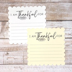 Puede incluir: Dos tarjetas de notas cuadradas con bordes festoneados, una blanca y otra de color amarillo p&aacute;lido. Cada tarjeta presenta el texto impreso en negro I AM Thankful FOR sobre una peque&ntilde;a ilustraci&oacute;n de una hoja y cinco l&iacute;neas horizontales.