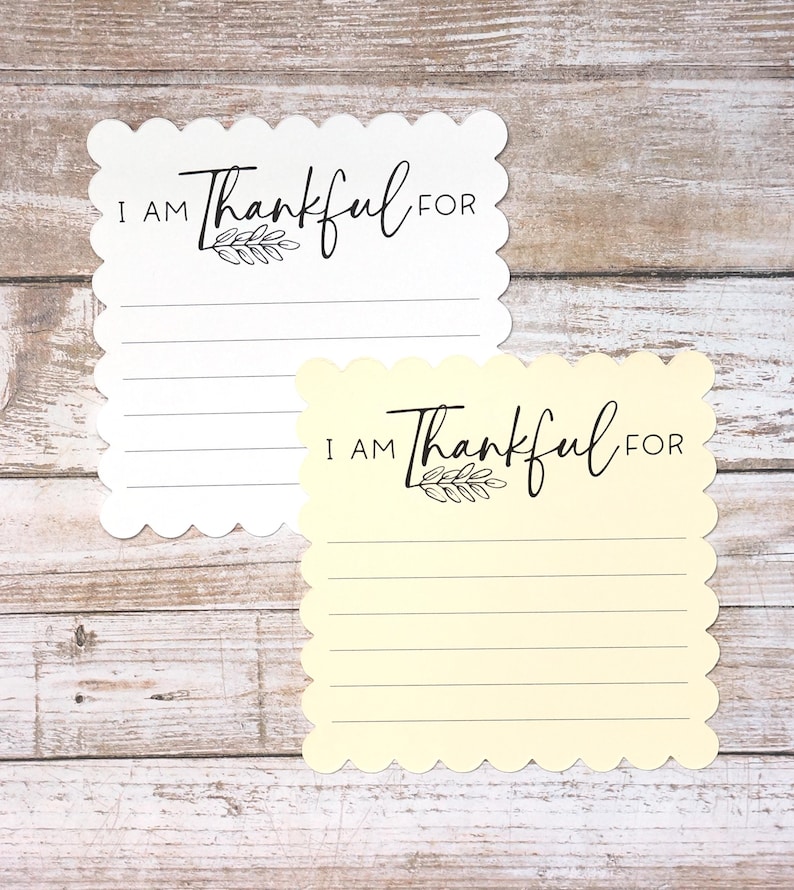 Puede incluir: Dos tarjetas de notas cuadradas con bordes festoneados, una blanca y otra de color amarillo p&aacute;lido. Cada tarjeta presenta el texto impreso en negro I AM Thankful FOR sobre una peque&ntilde;a ilustraci&oacute;n de una hoja y cinco l&iacute;neas horizontales.