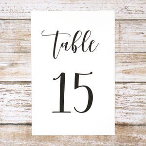 May include: White card with black text that reads "Table 15".
