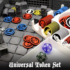 Puede incluir: Un conjunto de fichas universales con pilas de marcadores de juego circulares en rojo, amarillo, azul y blanco con varios iconos que incluyen calaveras y llamas. El set incluye dos dados poliédricos en morado y verde, organizados en una bandeja.