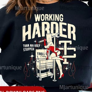 Könnte beinhalten: Schwarzes Sweatshirt mit dem Text "WORKING HARDER THAN AN UGLY STRIPPER" und einer Grafik einer Frau in roter Unterwäsche. Das Bild enthält auch den Text "TROLL Clothing" und "DIGITAL DOWNLOADS PNG".