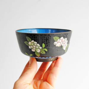 May include: A set of three ceramic nesting bowls in shades of blue, green, and white. The bowls feature a speckled glaze and a simple, modern design. The largest bowl measures approximately 8 inches in diameter.