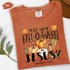 May include: Orange Comfort Colors t-shirt with the text "are you FALL-O-WEEN JESUS?" and a graphic of pumpkins and fall leaves. The text "matthew 4:19" is below the word "JESUS?"