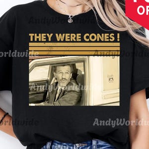 Puede incluir: Camiseta negra con el texto "THEY WERE CONES!" encima de una imagen en sepia de un hombre en un coche. La camiseta tambi&eacute;n tiene el texto "DIGITAL DOWNLOADS PNG" en la parte inferior. Una pancarta roja con "70% OFF" est&aacute; en la esquina superior derecha.
