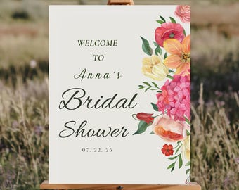 Könnte beinhalten: Ein weißes Willkommens-Schild mit floralen Akzenten in Rosa-, Gelb- und Orangetönen. Das Schild lautet "Willkommen zu Annas Bridal Shower 07.22.25".