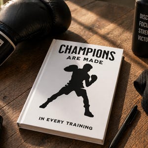 May include: A motivational book with the text "CHAMPIONS ARE MADE IN EVERY TRAINING" and a silhouette of a boxer. Black boxing gloves, a water bottle with motivational words, and a jump rope are also visible.
