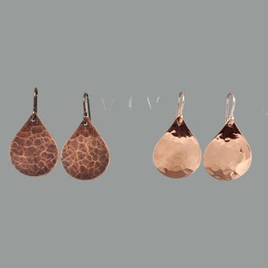 May include: Two pairs of hammered copper earrings. The earrings on the left are a darker copper color, while the earrings on the right are a lighter copper color.