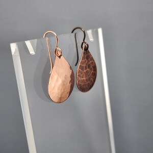 May include: A pair of hammered copper teardrop earrings with a rose gold finish.
