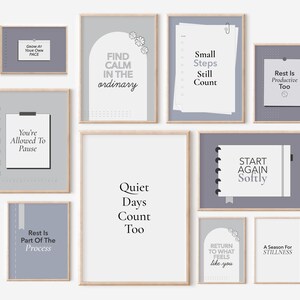 Può includere: Una collezione di stampe artistiche incorniciate con citazioni ispiratrici in stile minimalista. Le stampe presentano frasi come "Find Calm in the Ordinary" e "Start Again Softly" in una palette di colori neutri di grigio, bianco e beige.