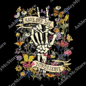 Puede incluir: Un diseño gráfico con una mano esquelética que emerge de un lecho de flores coloridas y mariposas. La mano sostiene pancartas con las palabras "HAVE THE DAY" y "YOU DESERVE" sobre un fondo negro. Las flores incluyen margaritas y rosas.