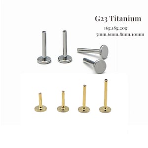 Puede incluir: Una variedad de joyas para el cuerpo de titanio G23, que incluyen tachuelas labret de espalda plana en tonos plateados y dorados. Los tamaños incluyen 16g, 18g, 20g y diámetros de 5 mm, 6 mm, 8 mm y 10 mm. Se muestra el texto "G23 Titanium".