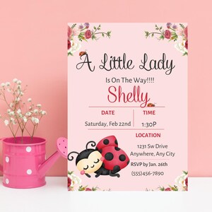 May include: Pink baby shower invitation with floral accents and ladybug illustrations. The invitation reads "A Little Lady Is On The Way!!!! Shelly" with date, time, and location details. A pink watering can with white polka dots and flowers is on the left.