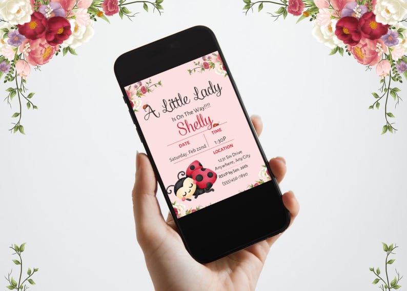 May include: A smartphone displays a baby shower invitation with the text "A Little Lady Is On The Way!!!" and the name "Shelly." The invitation features ladybug illustrations and floral accents. The date is Saturday, Feb 22nd, at 1:30 PM.