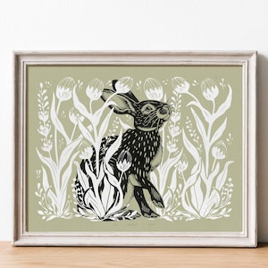 May include: Framed art print featuring a black and white illustration of a hare amidst white floral elements on a muted green background. The artwork is presented in a white distressed wooden frame, suitable for home decor.