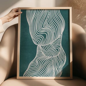 May include: A framed wall art print featuring a deep teal background with a series of white, flowing, parallel lines that create an abstract, organic, and undulating pattern across the vertical rectangular surface of the artwork.