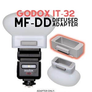 May include: A white Godox IT-32 MF-DD diffuser adapter for a camera flash. The set includes a translucent white dome diffuser and a grey rectangular mounting adapter. The text GODOX IT-32 MF-DD DIFFUSER ADAPTER is visible at the top of the image.