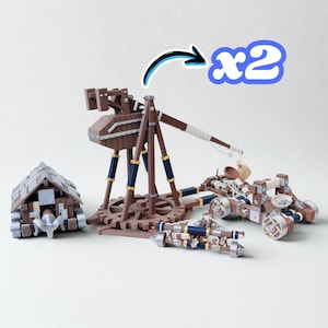 May include: A set of wooden model siege weapons, including a trebuchet, a battering ram, and two catapults. The models are brown with blue and gold accents. The image shows two catapults.