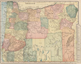 May include: A detailed vintage map of Oregon, showing the counties in various pastel colours. The map includes the word "Oregon" at the top and is framed with a decorative border. The map uses imperial measurements and is a historical cartographic representation.