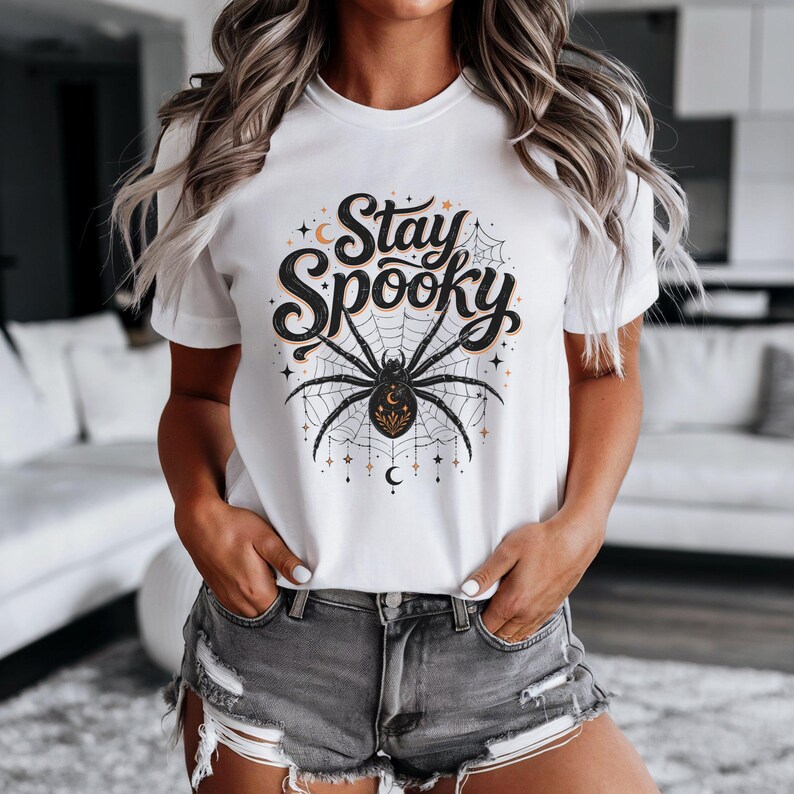 White t-shirt with black and orange spider graphic and "Stay Spooky" text.