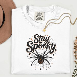 White t-shirt with "Stay Spooky" text and a spider graphic.