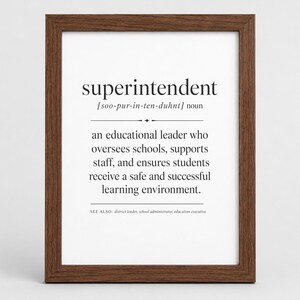 Peut inclure: Une affiche encadrée présentant la définition du dictionnaire du mot superintendent. Le texte inclut la prononciation phonétique, la classification en tant que nom et une description d'un leader éducatif qui supervise les écoles.