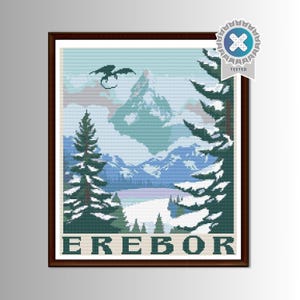 Puede incluir: Arte de punto de cruz de un paisaje montañoso con un dragón en el cielo. La obra presenta árboles cubiertos de nieve, montañas y un lago, con la palabra "EREBOR" en la parte inferior. La imagen está enmarcada en un marco de madera marrón.