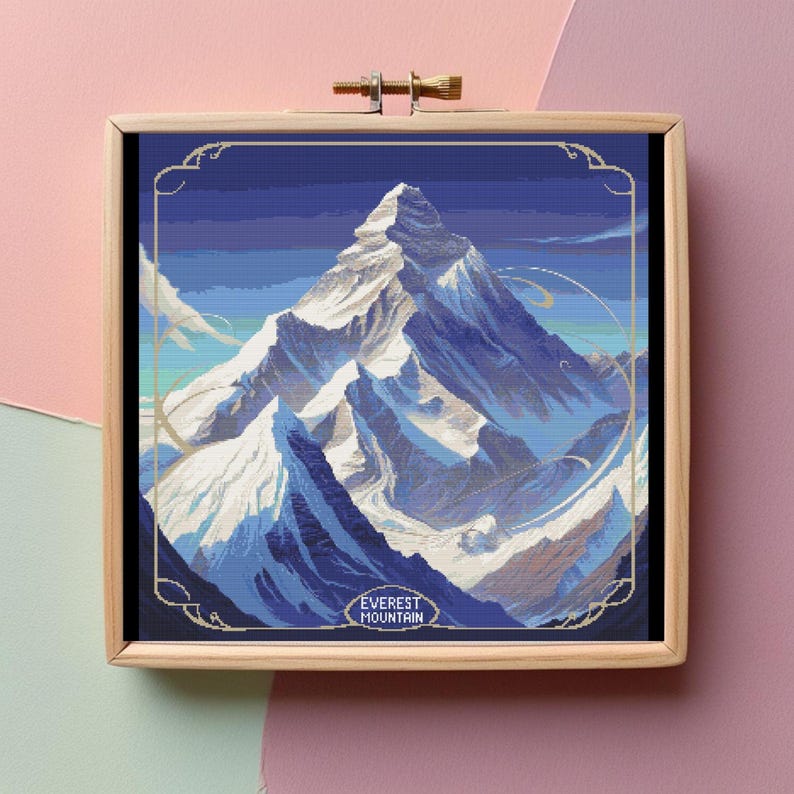 May include: A framed cross-stitch embroidery of Mount Everest, a snow-capped mountain range with a blue sky and white clouds. The text "EVEREST MOUNTAIN" is at the bottom of the image.