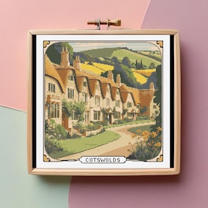 May include: A cross-stitch pattern featuring a picturesque scene of a row of charming cottages in the Cotswolds, England. The cottages are painted in warm tones with thatched roofs and surrounded by lush greenery. The scene is framed by a wooden frame.