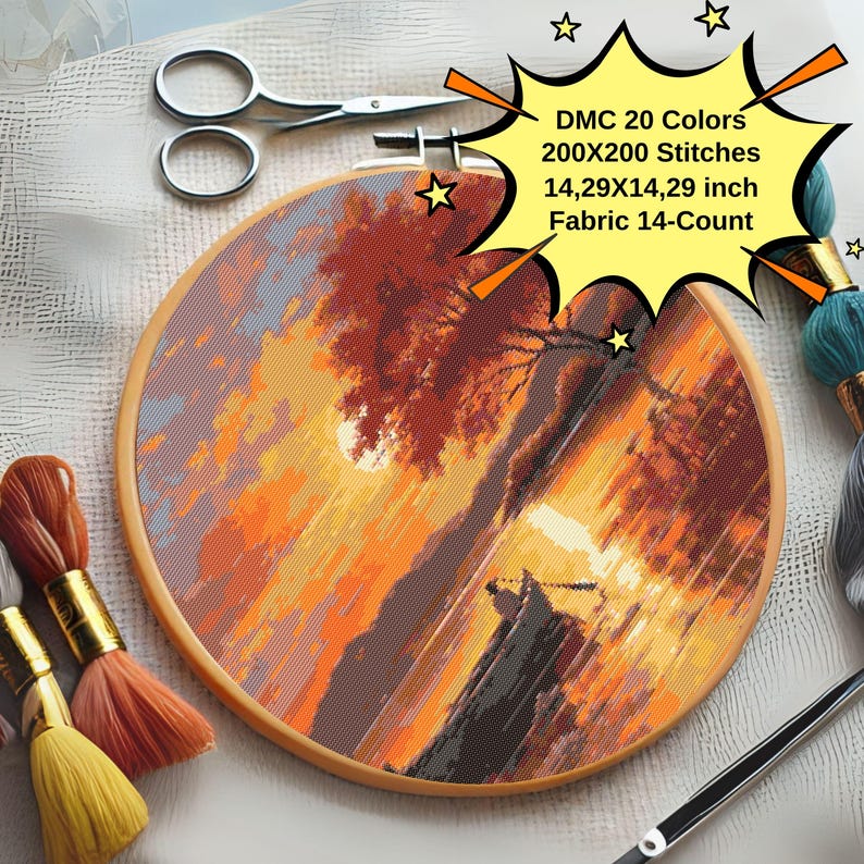 K&ouml;nnte beinhalten: Eine Nahaufnahme eines runden Stickrahmens mit einem Kreuzstich-Motiv eines Sonnenuntergangslandschafts. Das Motiv zeigt einen See, B&auml;ume und eine Sonne, die &uuml;ber dem Wasser untergeht. Der Rahmen hat einen Durchmesser von 36,3 cm und ist aus 14-z&auml;hlgem Stoff gefertigt. Der Text auf dem Rahmen lautet "DMC 20 Farben 200X200 Stiche 36,3X36,3 cm Stoff 14-Z&auml;hl".