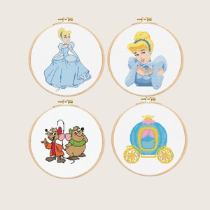 Op de afbeelding: Vier borduurringen met kruissteek met Assepoester-personages. De ontwerpen omvatten Assepoester in een blauwe jurk, Assepoester met gevouwen handen, twee muizen in rode en groene outfits en een blauwe koets met gouden wielen.