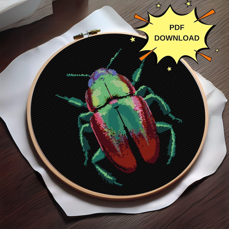 May include: A cross-stitch embroidery hoop with a colorful beetle design. The beetle is green, red, and black with a detailed design. The background is black.