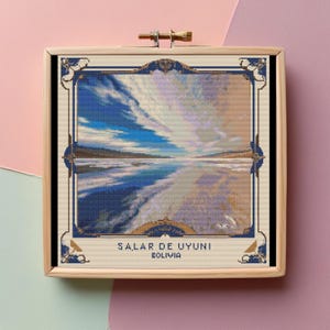 May include: A framed cross-stitch artwork depicting a scenic view of Salar de Uyuni, Bolivia. The image features a vast, white salt flat with a blue sky and clouds reflected in the water.